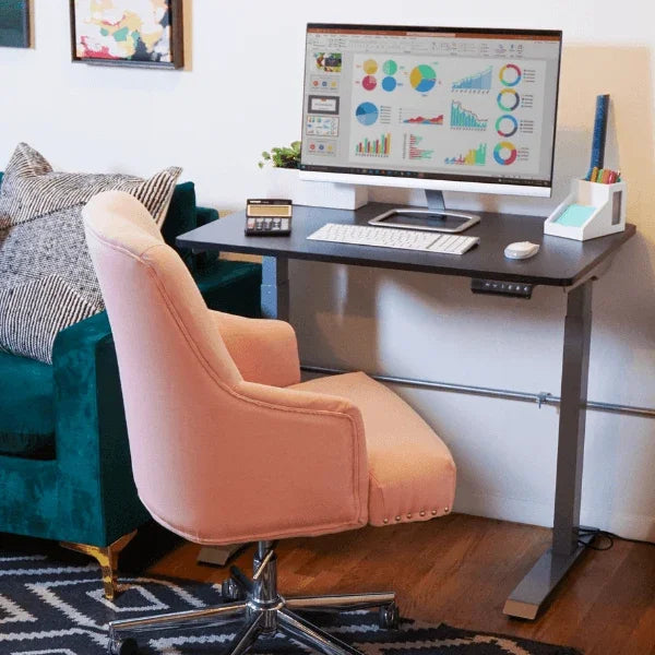 Victor® High Rise™ compact electric standing desk with a pink office chair and monitor.
