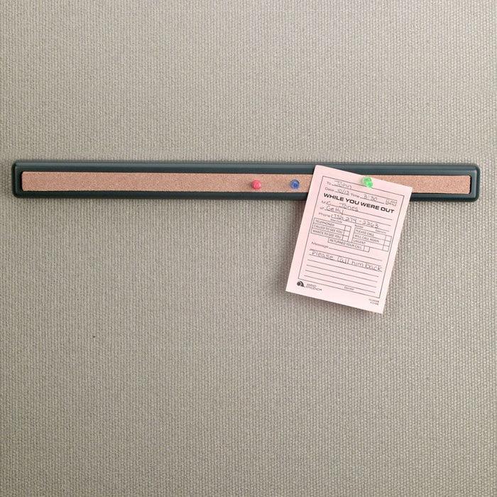 Cork bar strip on office wall holding a note with colored push pins, workspace organizer