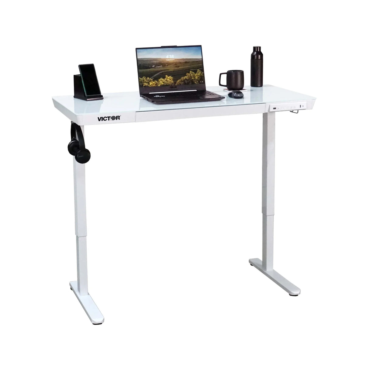 Electric glass-topped standing desk with laptop, mug, bottle, and phone on white background