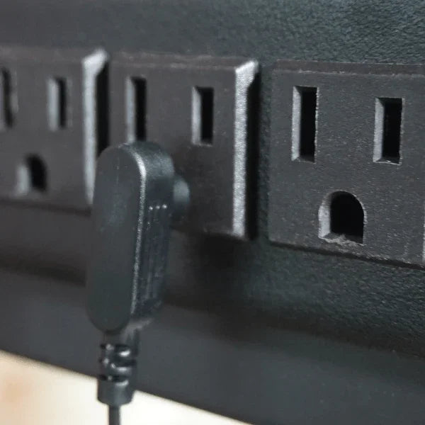 Close-up of a Victor® Grounding Desk Pad plug connected to a power outlet.