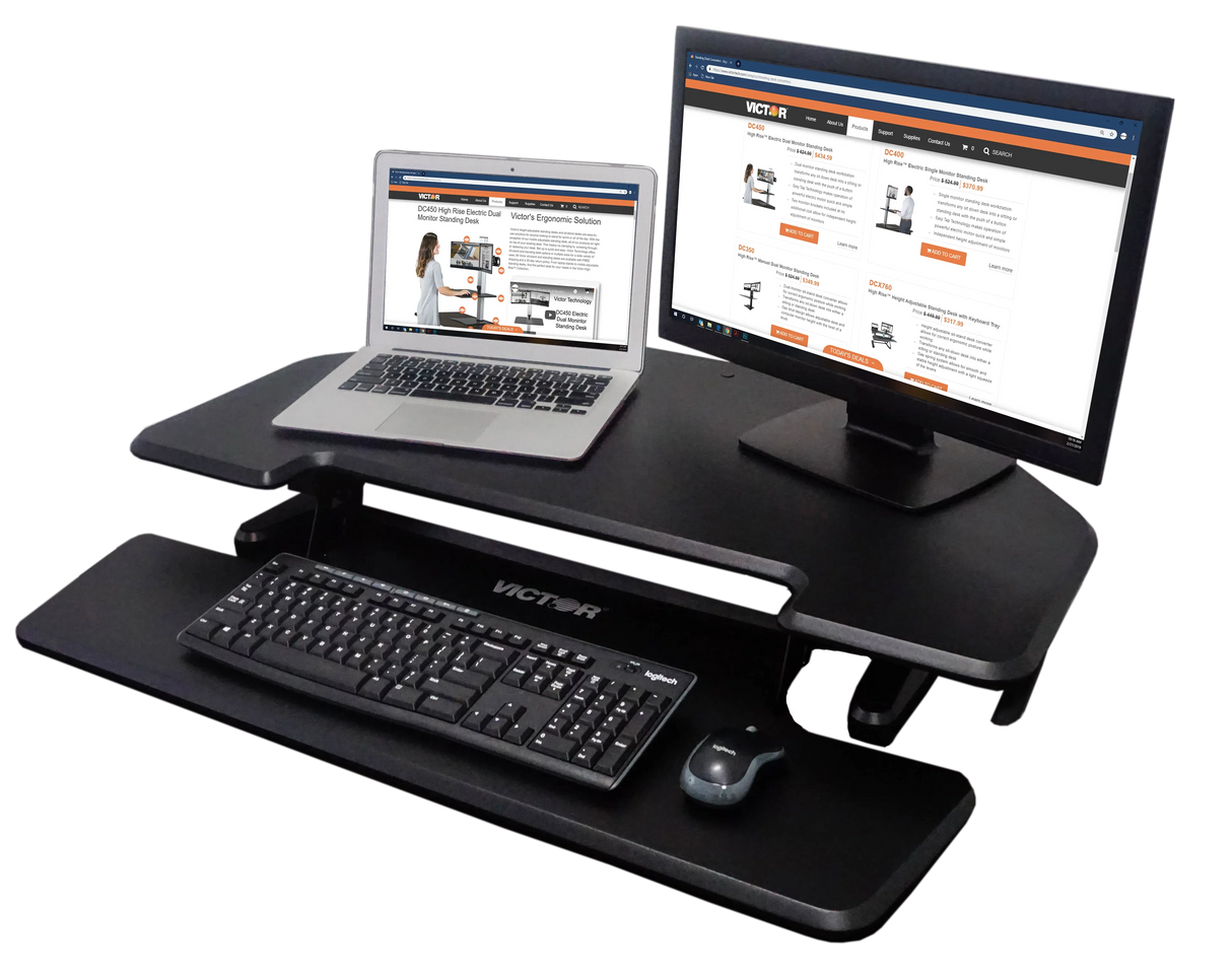 High-rise adjustable corner standing desk with monitor, laptop, keyboard, and mouse