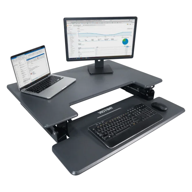 Adjustable height standing desk with keyboard tray, laptop, monitor, and mouse setup