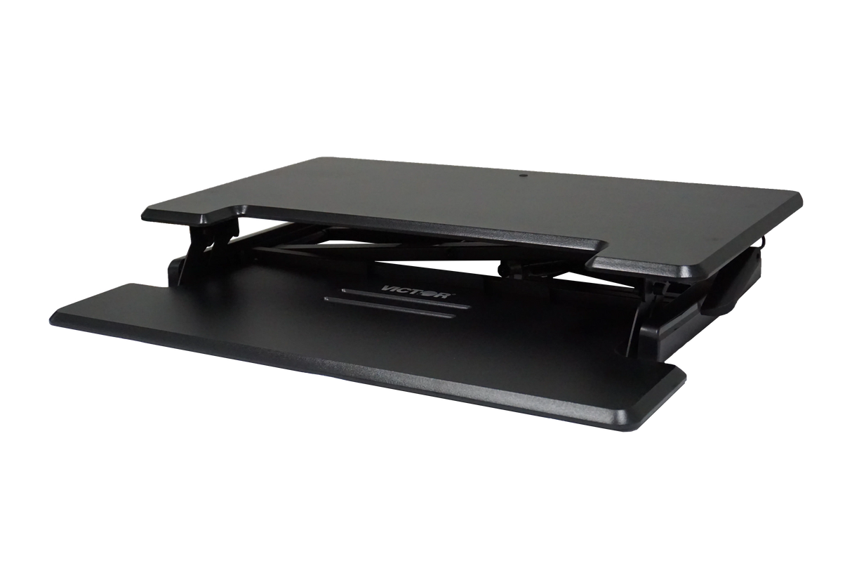 Black adjustable standing desk converter with a raised keyboard tray on white background