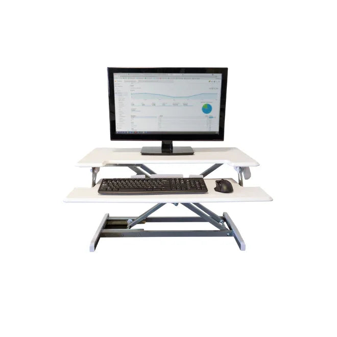 White adjustable height standing desk with monitor, keyboard, and mouse on keyboard tray