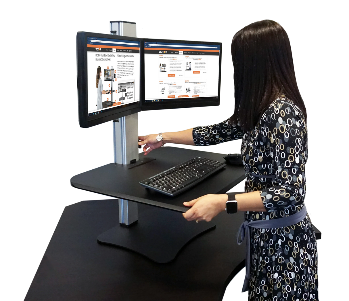 Woman using high-rise dual monitor standing desk with keyboard and adjustable platform