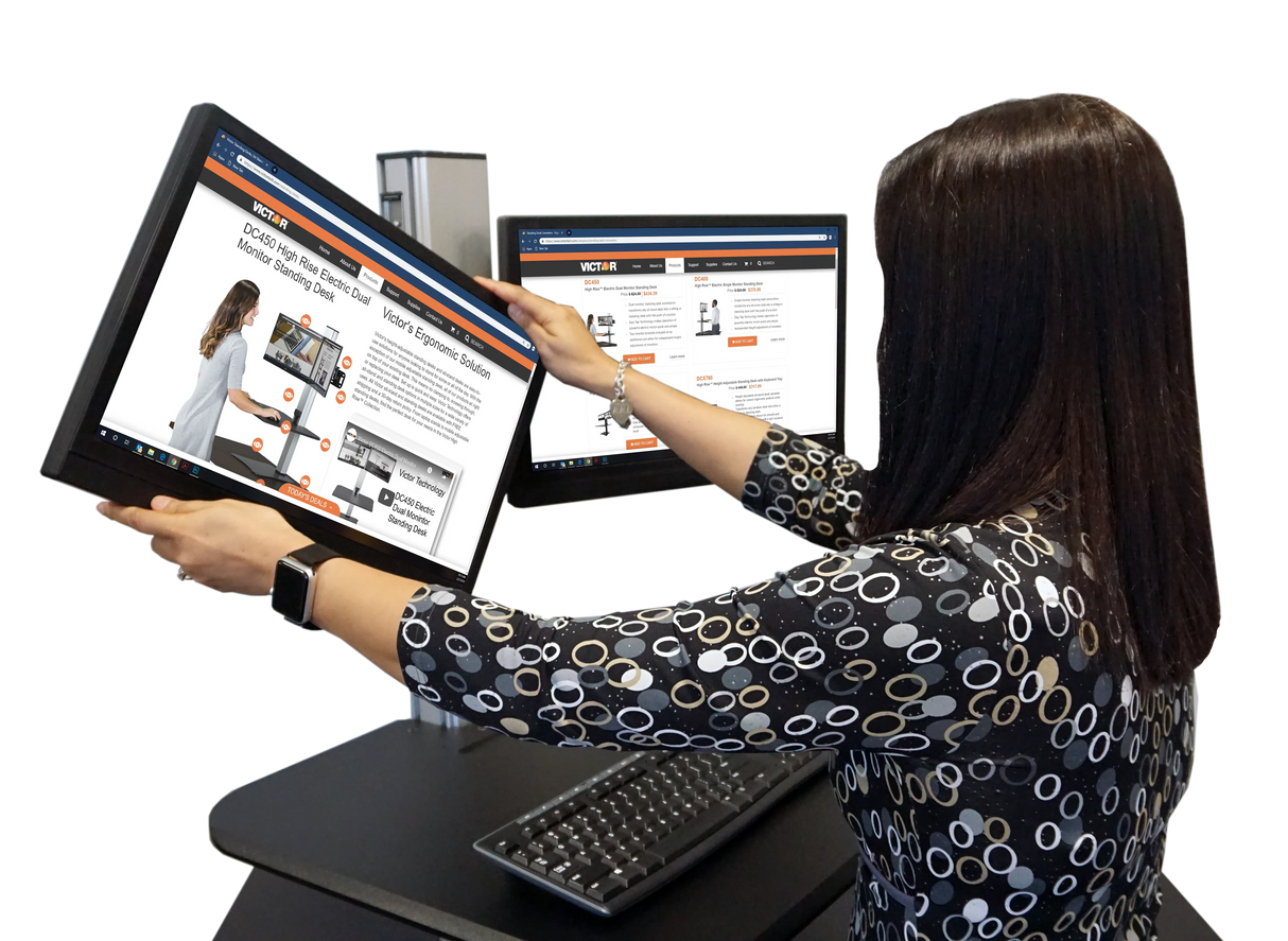 Woman adjusting monitors on a high rise dual monitor standing desk in office setting