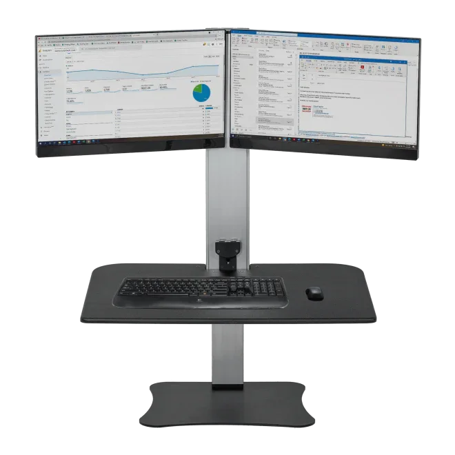 Electric adjustable standing desk with dual monitors, keyboard, and mouse on black surface.