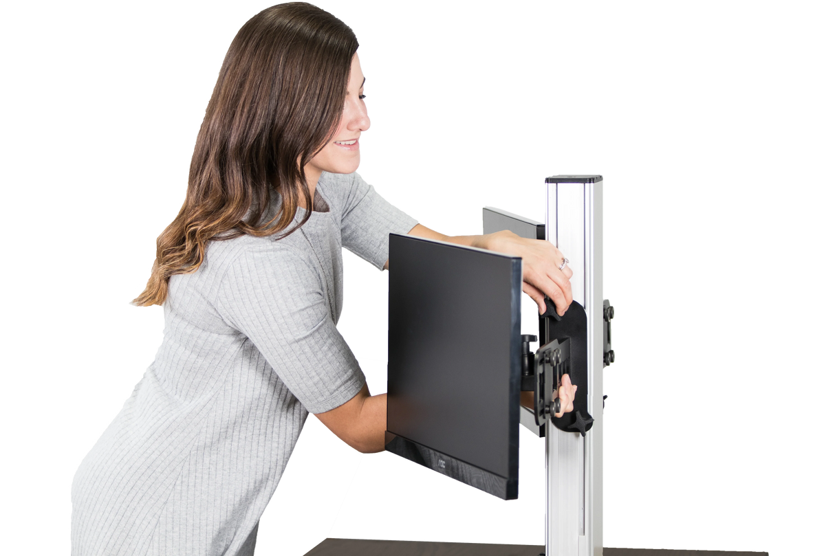 Woman adjusting dual monitor on electric standing desk frame
