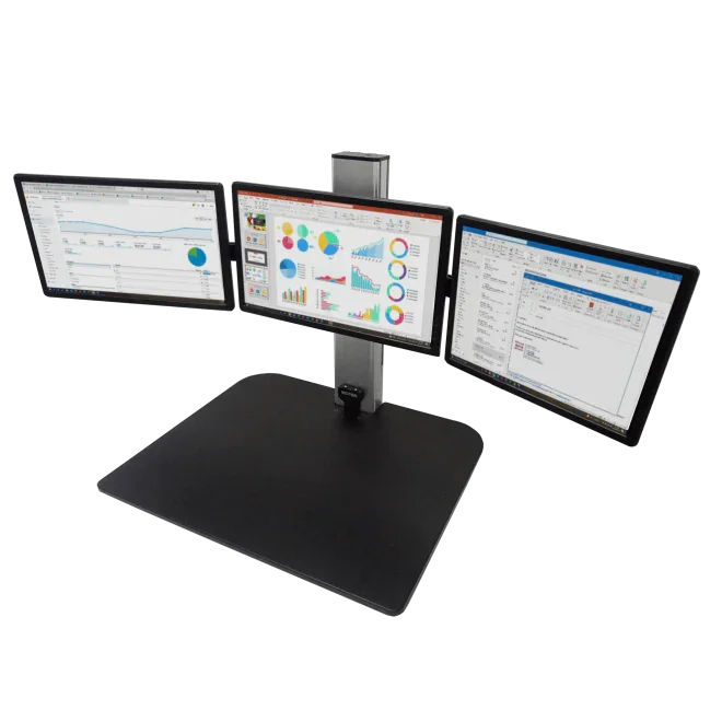 Electric standing desk converter with triple monitor mount, displaying business charts