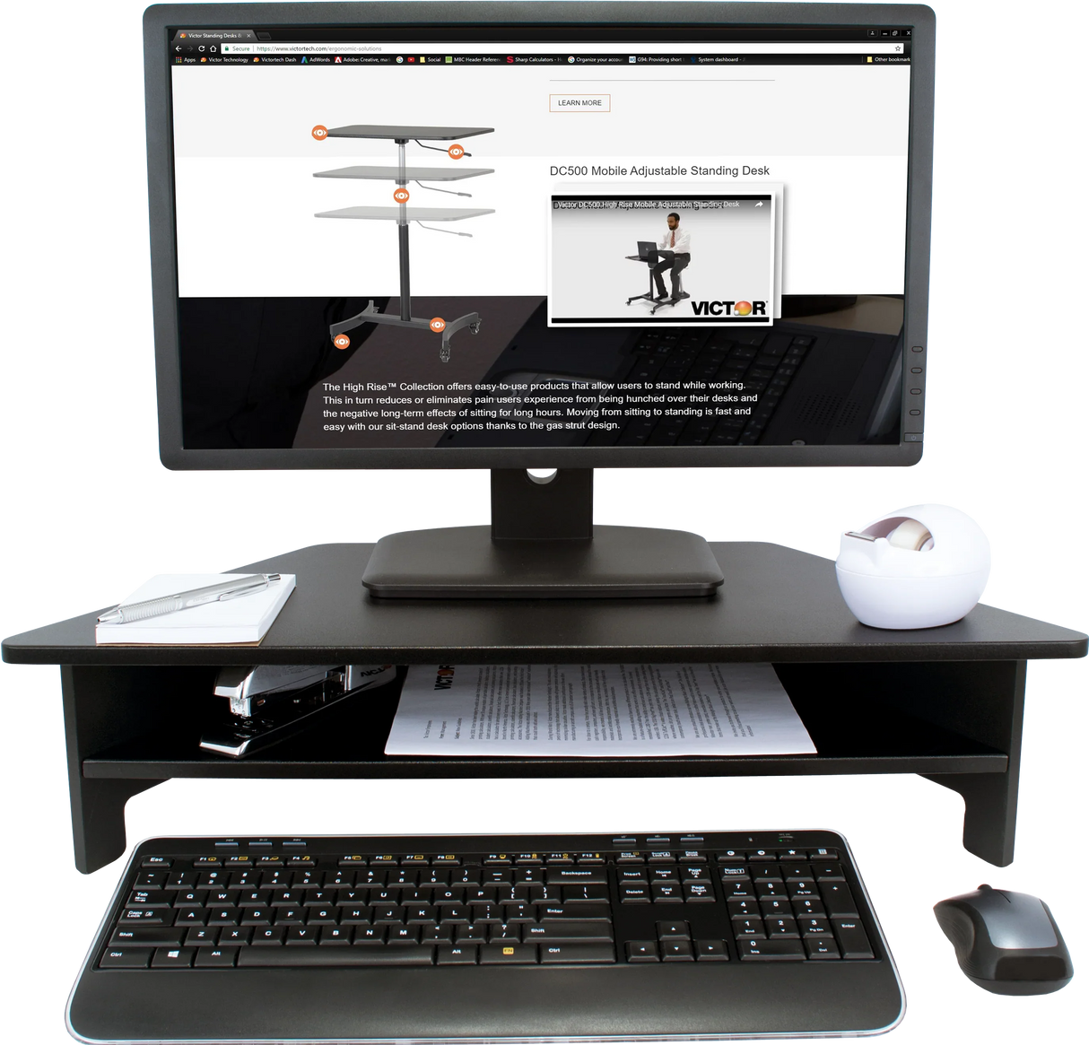 High rise monitor stand on desk with computer monitor, keyboard, mouse, stapler and notepad