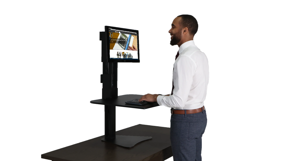 Man using high rise single monitor standing desk with keyboard in modern office