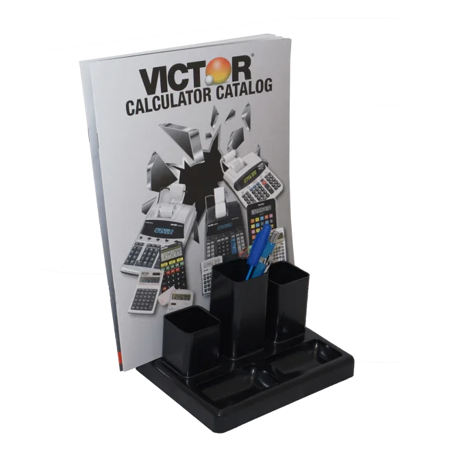Black recycled desktop organizer with pen holders and a magazine slot, holding pens and a catalog