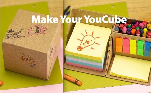 Desk organizer cube holding colorful sticky notes, crayons, and paper, on a wood surface.