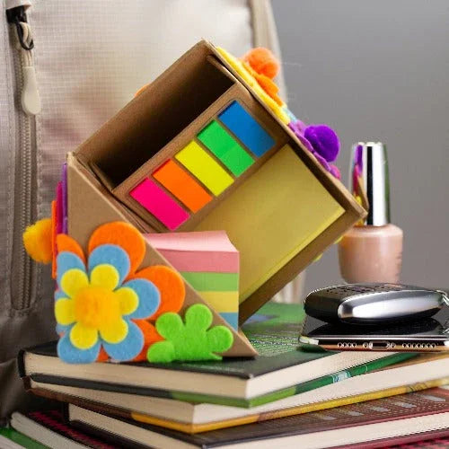 Colorful sticky notes storage organizer with flower decorations on stacked books