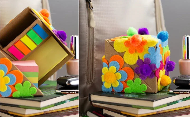 Colorful cube desk organizer decorated with felt flowers, holding sticky notes on books