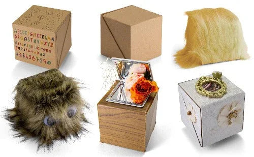 Six unique cube-shaped organizers, each decorated with different materials and textures.