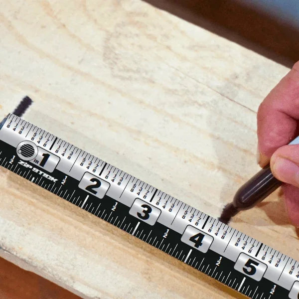 A person using a marker to mark a measurement on a Victor® Zip Stick magnetic tool on wood.