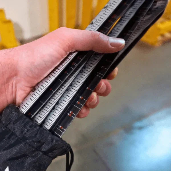 A hand holding a Victor Zip Stick 144" ProSpan Magnetic Measuring Tool.