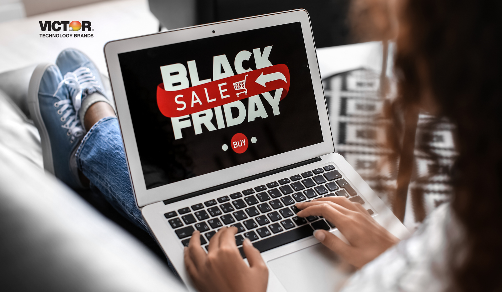 Person browsing Black Friday sale on laptop, online shopping, home workspace.