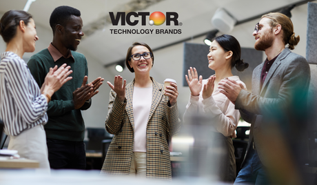 Diverse business team clapping and smiling in modern office, Victor Technology Brands logo above