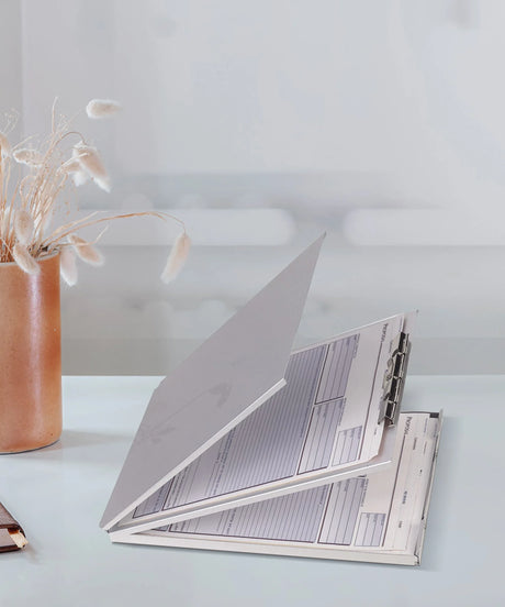 Open record-keeping form binder on desk with dried flowers, office supply organization