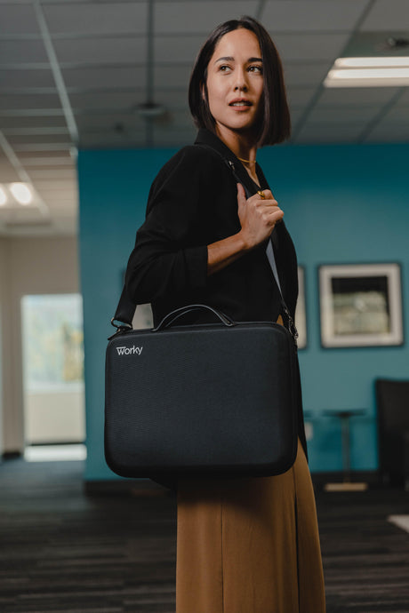 Woman carrying a black Worky laptop briefcase in a modern office setting