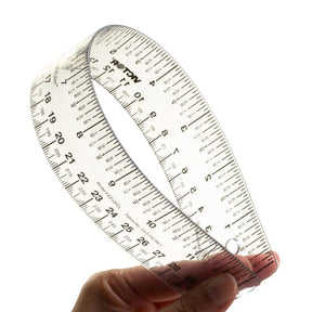A hand bending a clear Victor flexible Easy Read ruler showing measurement scales.