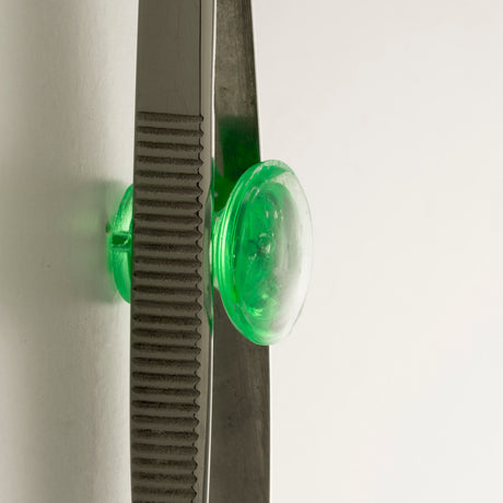 Metal compass with green plastic grip on white background, school and office supply