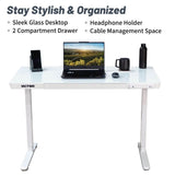 White desk with laptop, phone, and other items on a white background