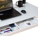 Laptop on a desk with a drawer open, showing office supplies.