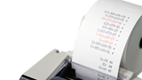Close-up of calculator printing tape with printed numbers, suitable for office or school use