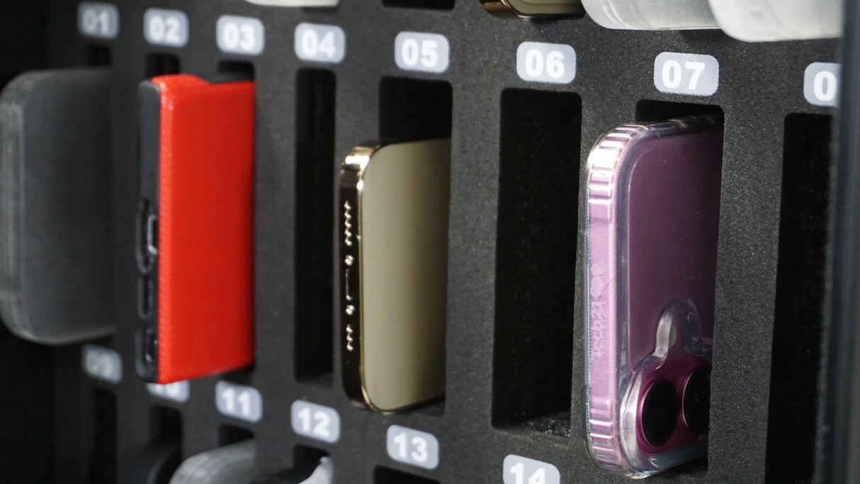 Row of smartphones in numbered foam organizer slots, including red and purple cases