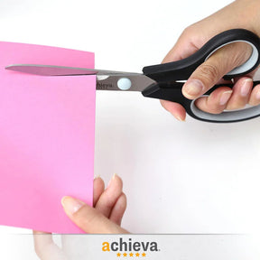 A person using Officemate craft scissors to cut a piece of pink paper.