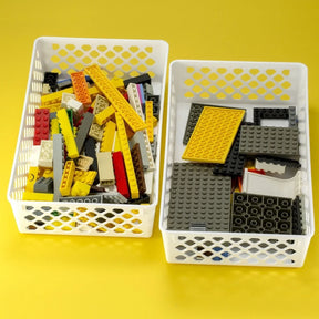 Two white Officemate Achieva supply baskets filled with colorful building blocks.