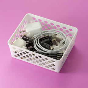 White Officemate® Achieva® supply basket filled with charging cables and power adapters.