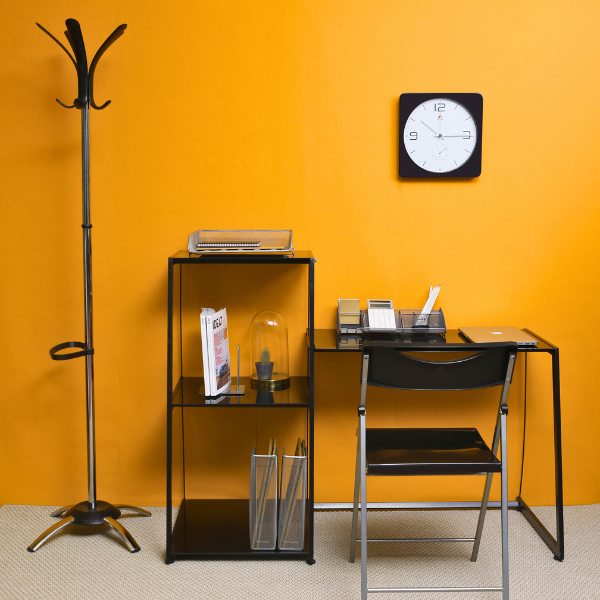Chrome coat stand with umbrella holder in modern office setting with orange wall