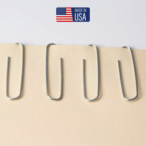 Four Officemate® Premium Large Paper Clips holding beige paper, with a Made in USA label.