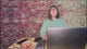 Woman demonstrating how a grounding desk pad works. 