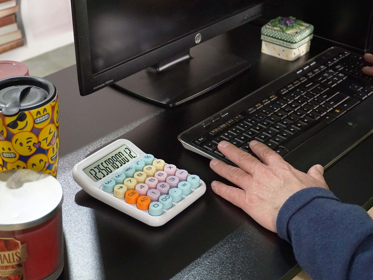 Colorful desktop calculator beside keyboard and monitor on an organized office desk