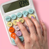 Hand with pastel nail polish pressing buttons on a pastel desktop calculator on pink background