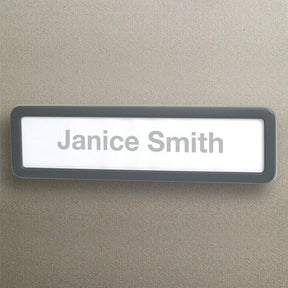 Officemate Verticalmate name plate with 'Janice Smith' text on a grey textured wall