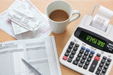 Thermal printing calculator, bank records, receipts, and coffee on office desk