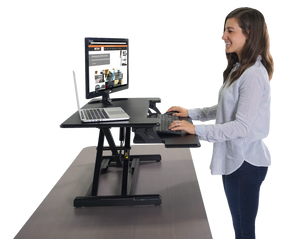 Woman using a Victor® High Rise™ Compact Adjustable Height Standing Desk with keyboard tray