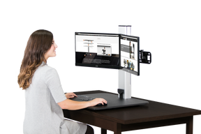Woman using Victor® High Rise™ Electric Dual Monitor Standing Desk with dual screens