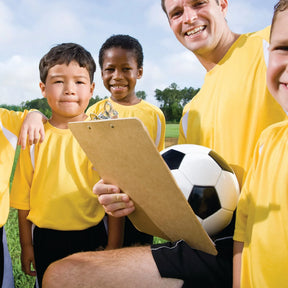 Coach holding an Officemate® wood clipboard with a youth soccer team in the background.