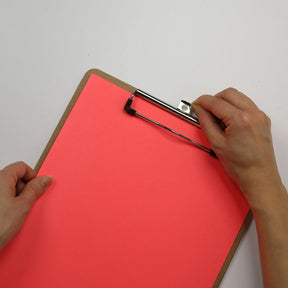 Hands holding an Officemate® wood clipboard with a low profile clip and bright red paper